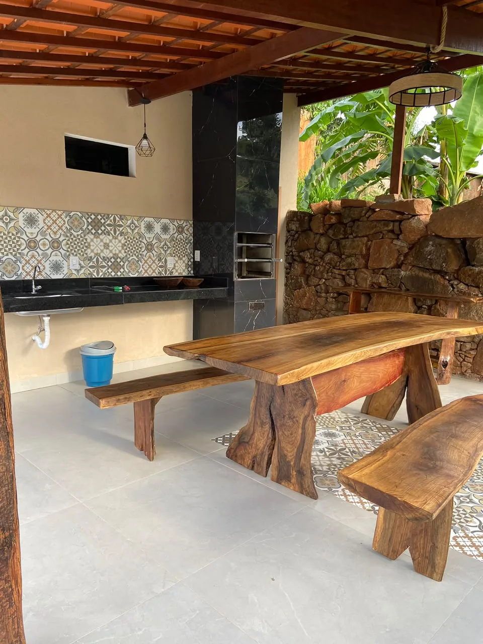 Mesa de madeira e churrasqueira na área coberta